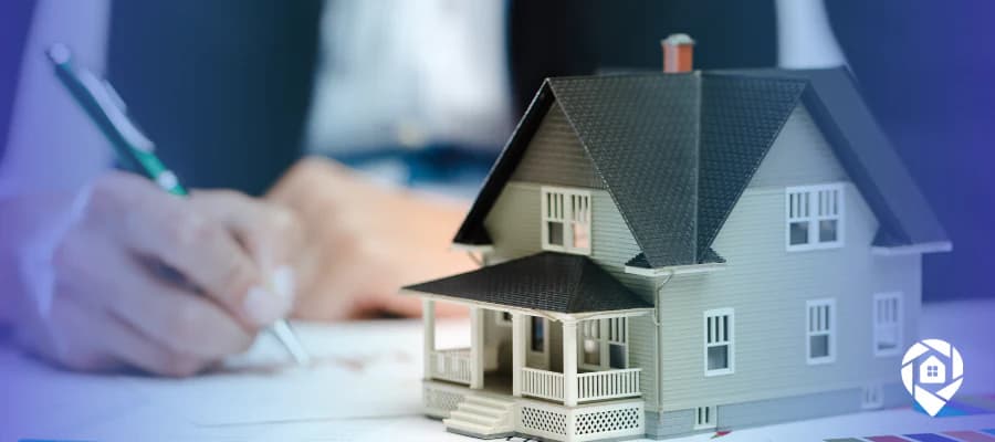 Real estate wholesaling strategy concept with model house and paperwork for scaling to 25 deals per month.