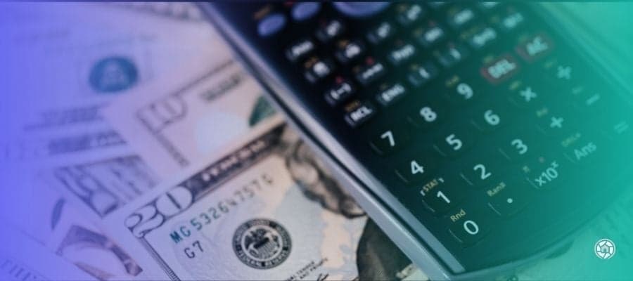 money and a calculator on a table to calculate capital gains tax on a real estate investment property