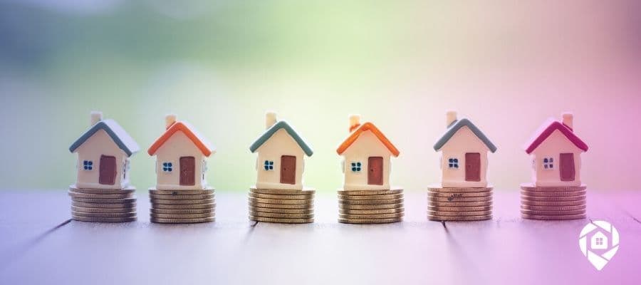 A line of tiny houses on coins to symbolize How to Find Profitable Investment Properties for Sale