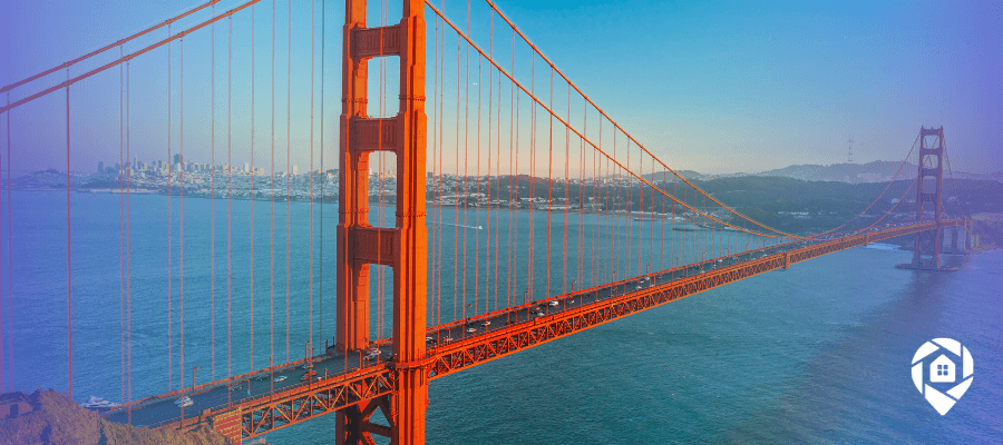 Aerial view of the Golden Gate Bridge spanning San Francisco Bay at dusk, with the city skyline in the background.