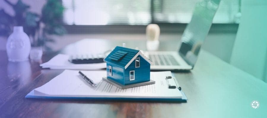 a tiny house on top of a clipboard on a desk