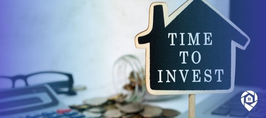 Time to invest in real estate sign with coins and calculator – start flipping, renting, or wholesaling properties for financial freedom.