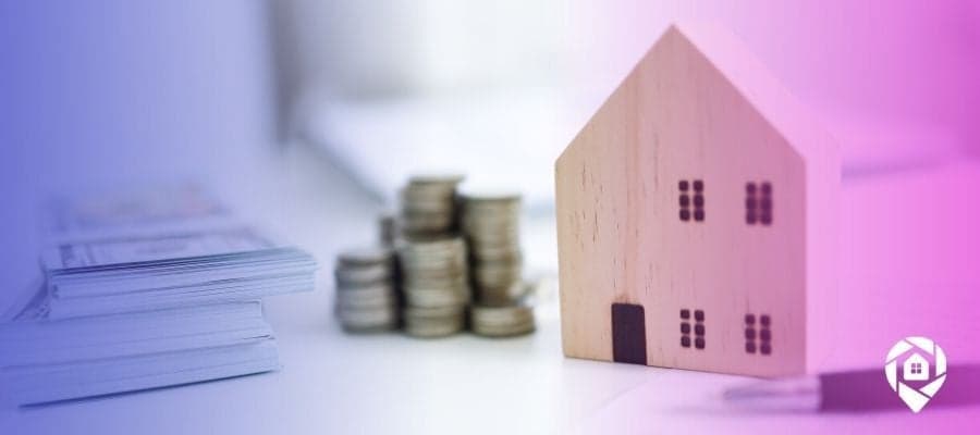 Picture of a wooden house next to money on a desk for what is a real estate tool blog.