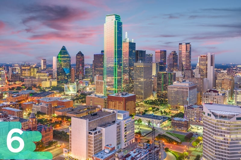 Aerial shot of downtown Dallas, Texas in the evening with each skyscraper lit up and reflecting lights.