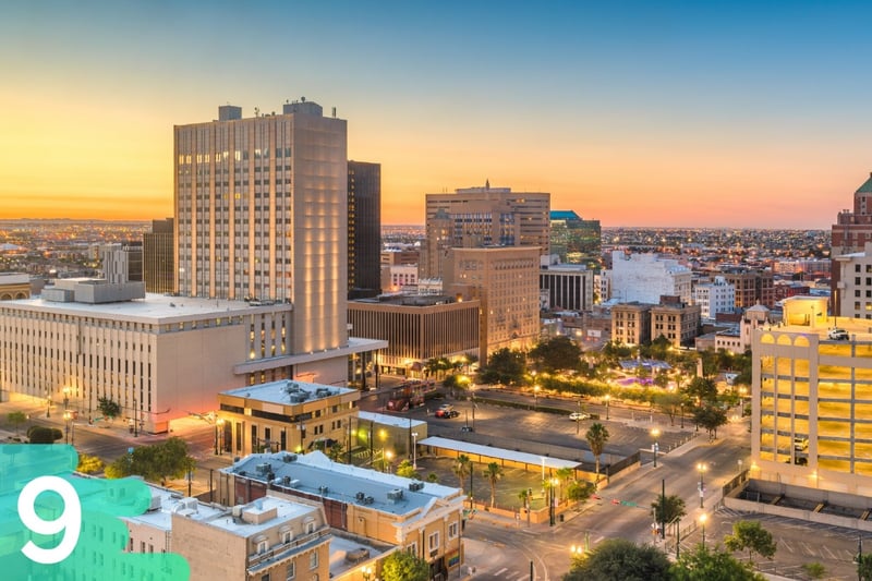 Downtown El Paso, Texas at sunset with the buildings all lit up and traffic lights in the background.
