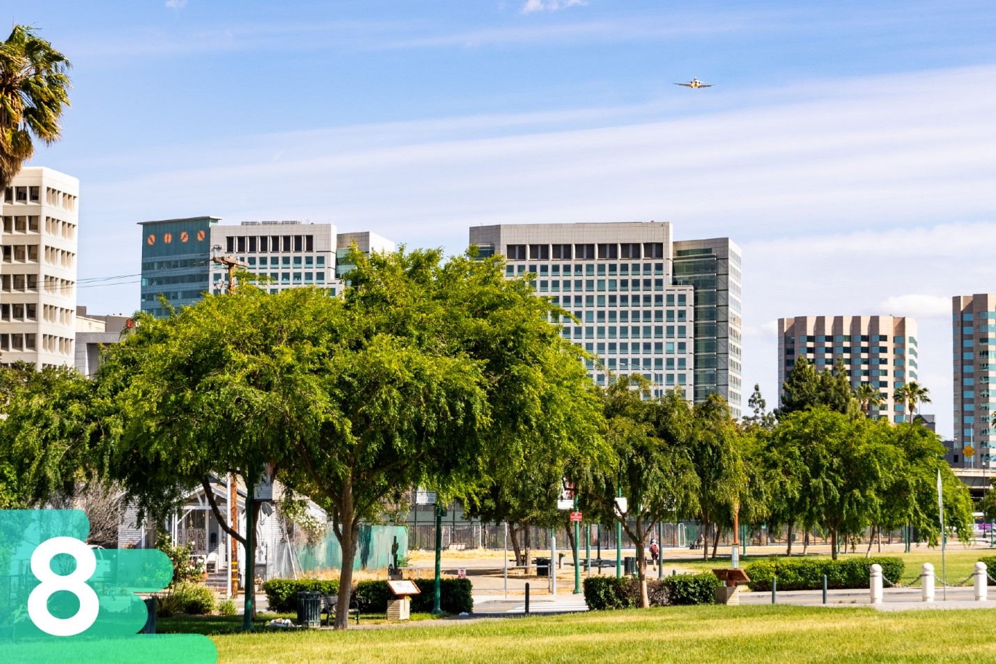 Park in San Diego featuring basketball courts, and skyscrapers in the background on a beautiful sunny day.